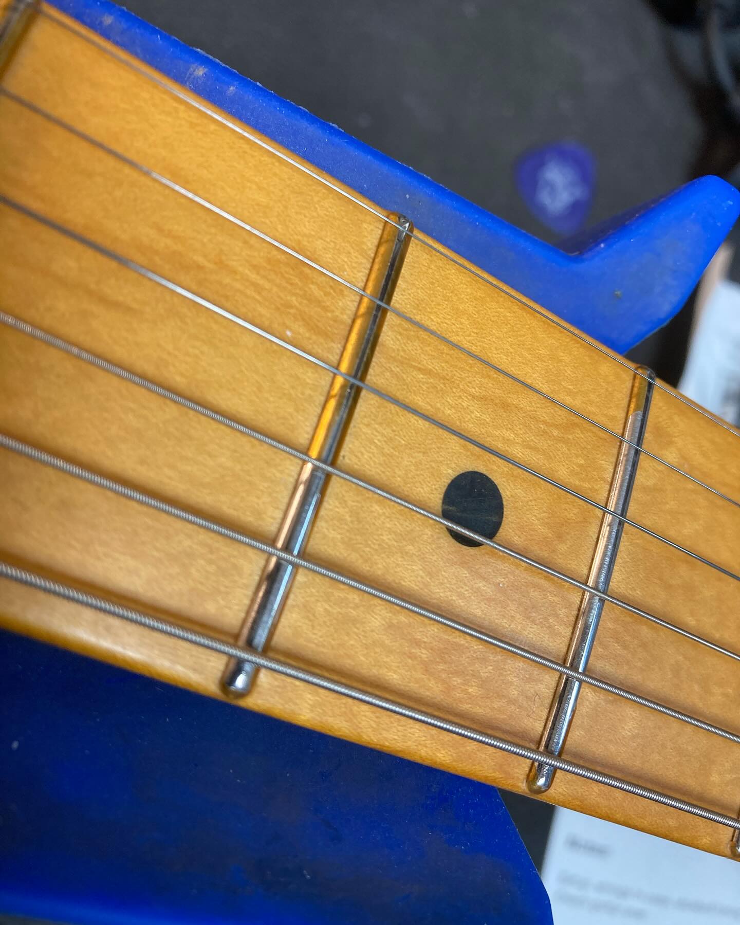 Guitar fretboard showing polyurethan  on frets