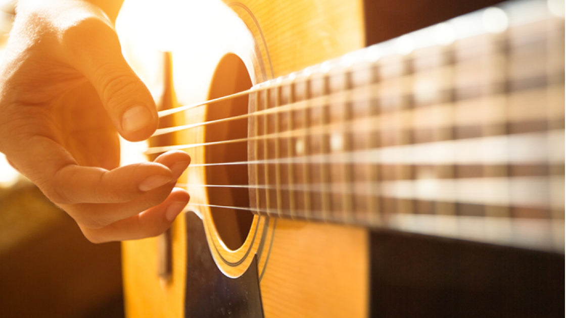 A hand fingerpicking guitar