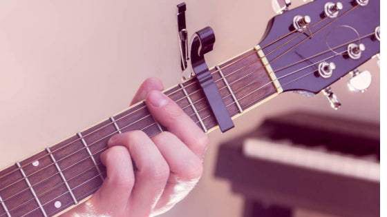 Guitar being played using a capo.