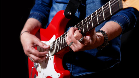 Man playing red guitar