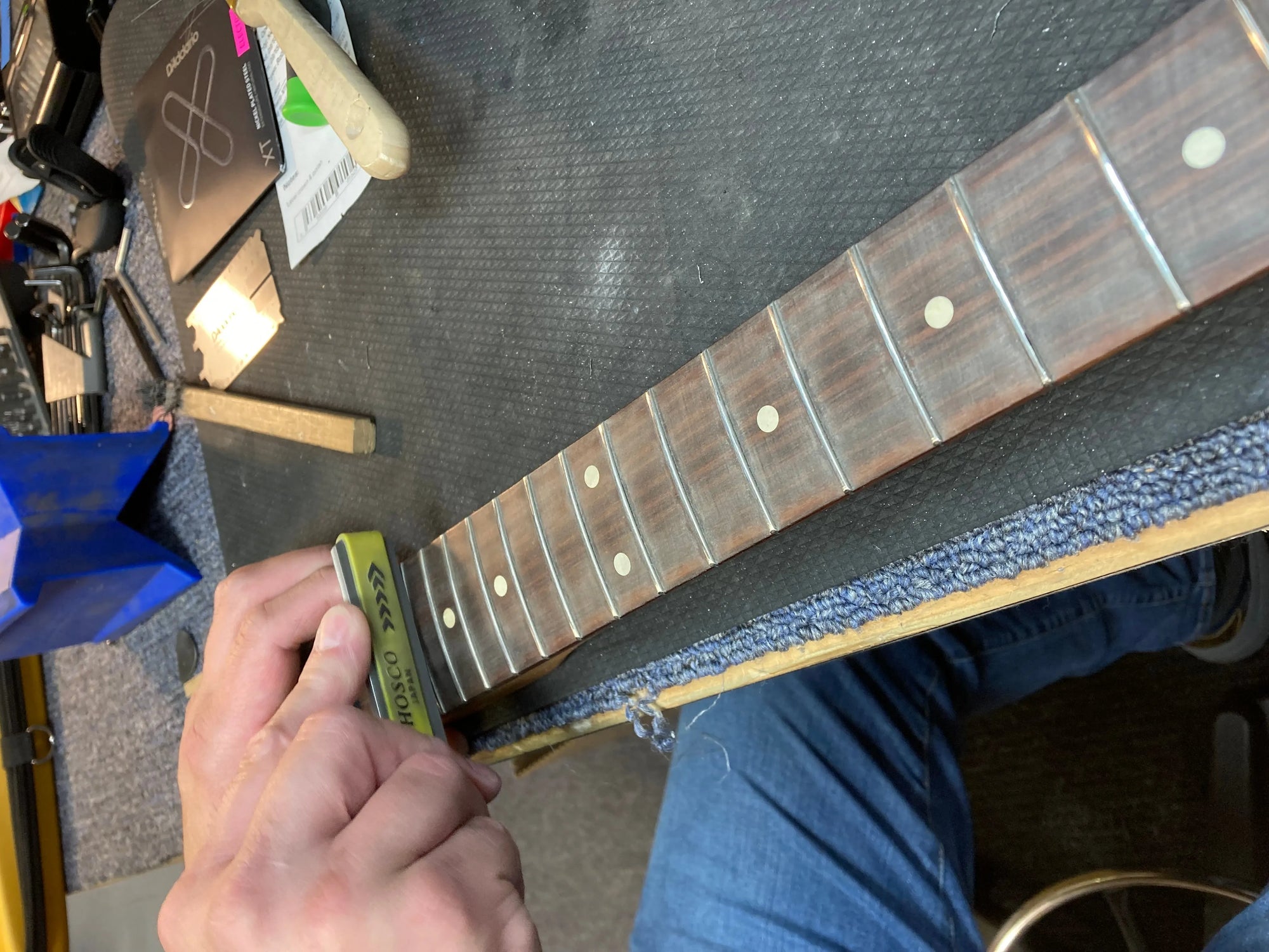 Fretwork being done to guitar neck