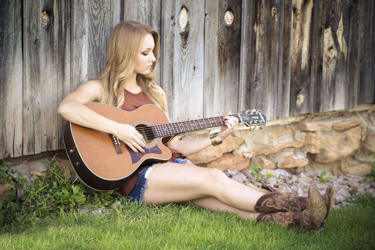 women sitting on ground playing guitar