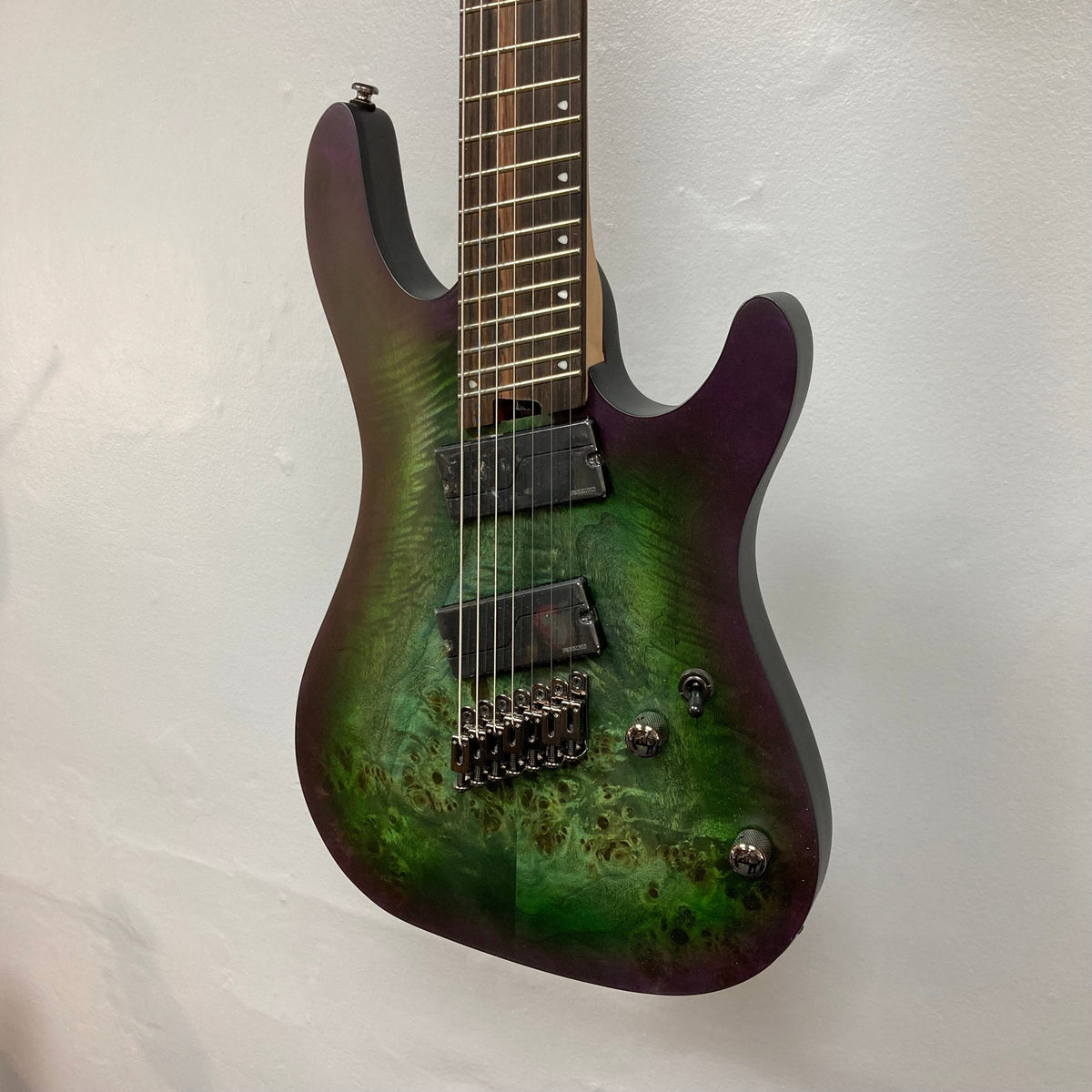 Cort KX507 SDG 7-String Multi-Scale electric guitar with green and purple finish, featuring multi-voiced Fishman Fluence Modern Humbucker pickups and individual hardtail bridge units.