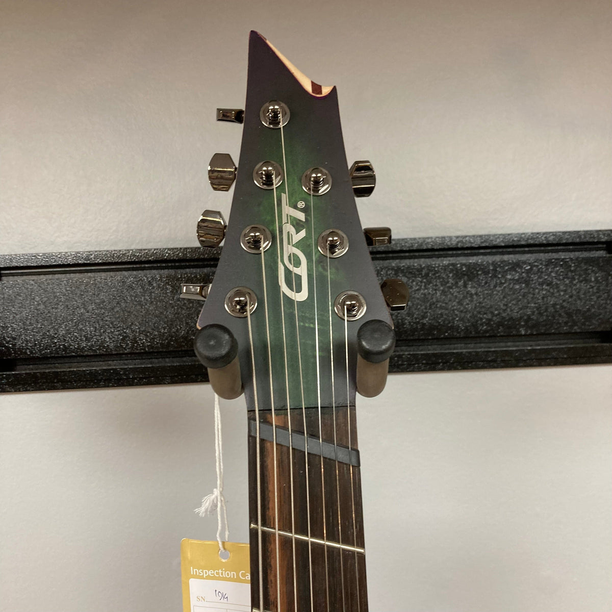 Cort KX507 SDG 7-String Multi-Scale Electric Guitar with Fishman Fluence pickups and Poplar Burl top, shown with a product tag attached.