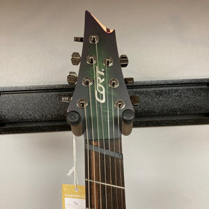 Cort KX507 SDG 7-String Multi-Scale Electric Guitar with Fishman Fluence pickups and Poplar Burl top, shown with a product tag attached.