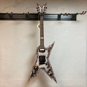 Dean Razorback Rust electric guitar with case, displayed on a wall, featuring a distinct rust graphic and minor blemishes.