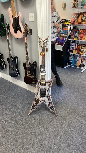 Dean Razorback Rust electric guitar with custom rust graphic, leaning against a wall, showcasing its professional-grade features and design. Includes case.