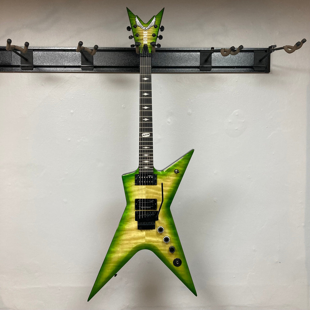 Dean Stealth Floyd FM Dime Slime electric guitar on a stand, featuring a flame maple top and ebony fretboard, displayed in-store.