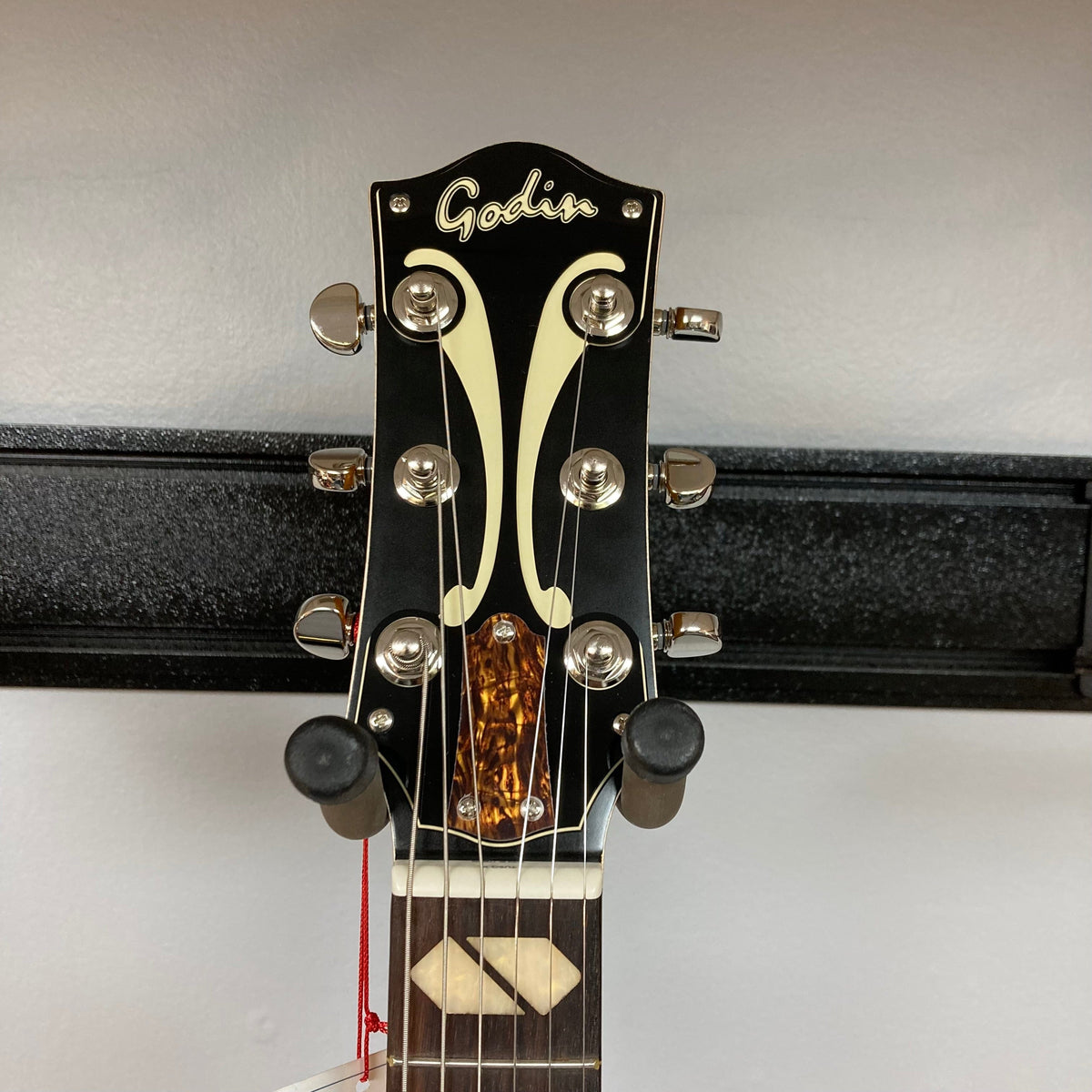 Godin 5th Avenue Jumbo P-Rail Harvest Gold guitar on a stand, showcasing its archtop design and detailed craftsmanship.