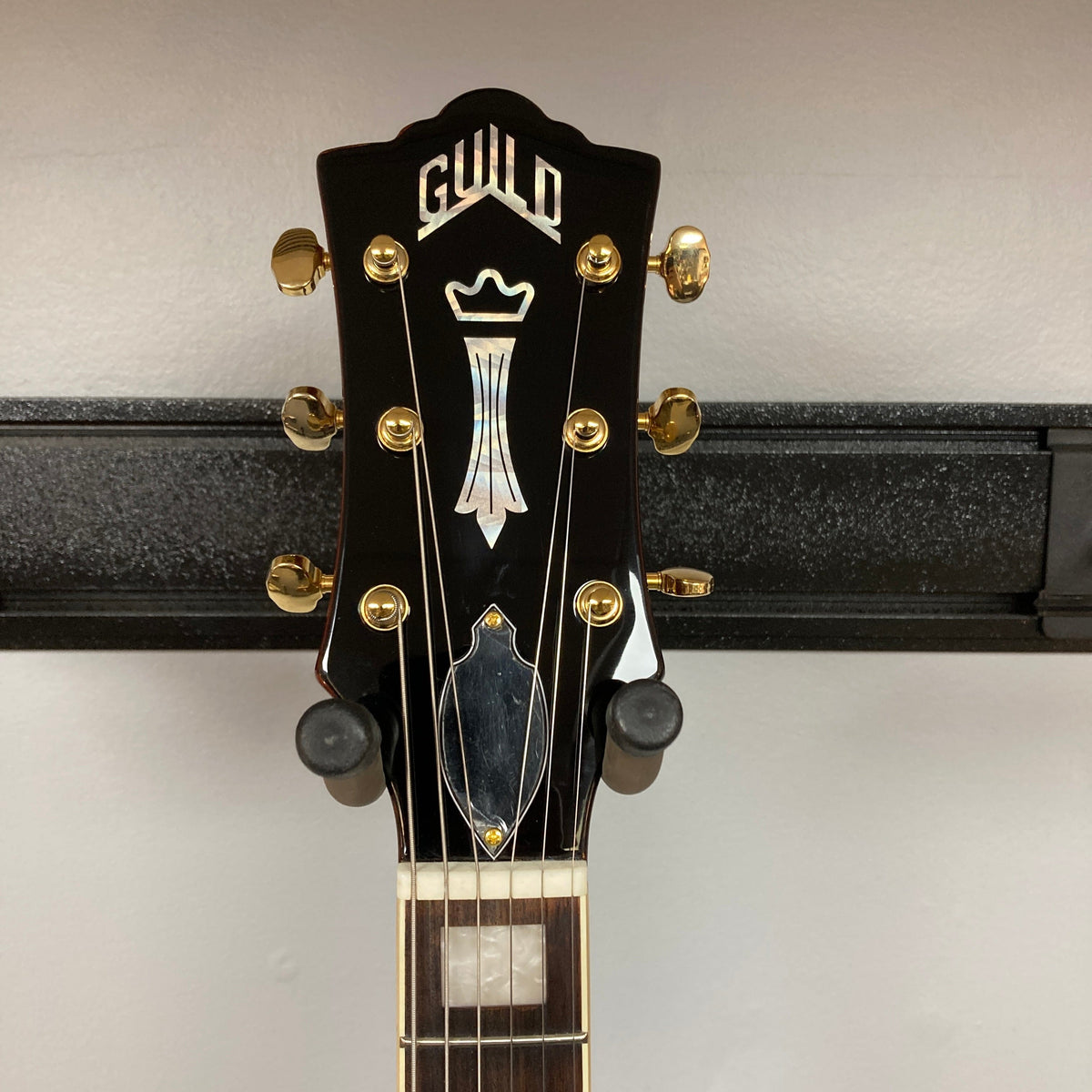 Guild Aristocrat P90 Consign guitar on a stand, showcasing its detailed neck and body, ideal for music enthusiasts and collectors.