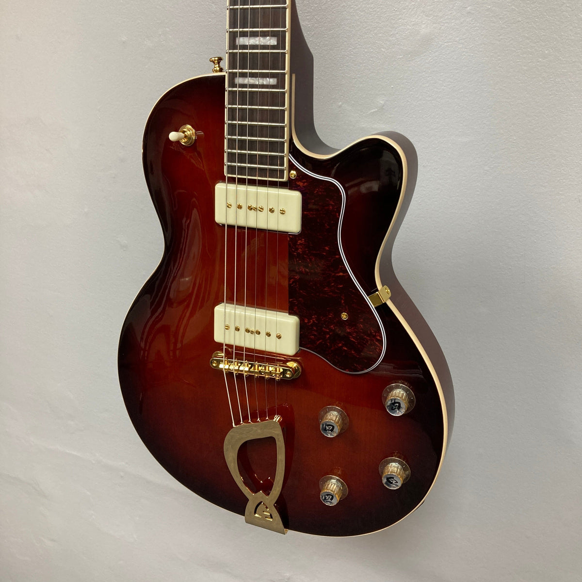 Guild Aristocrat P90 Consign electric guitar displayed on wall, showcasing strings and knobs, highlighting its craftsmanship and musical heritage.