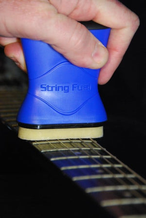 Person cleaning a guitar with a blue string cleaning tool, showcasing the Music Nomad Total Guitar Spa Kit for comprehensive guitar care.