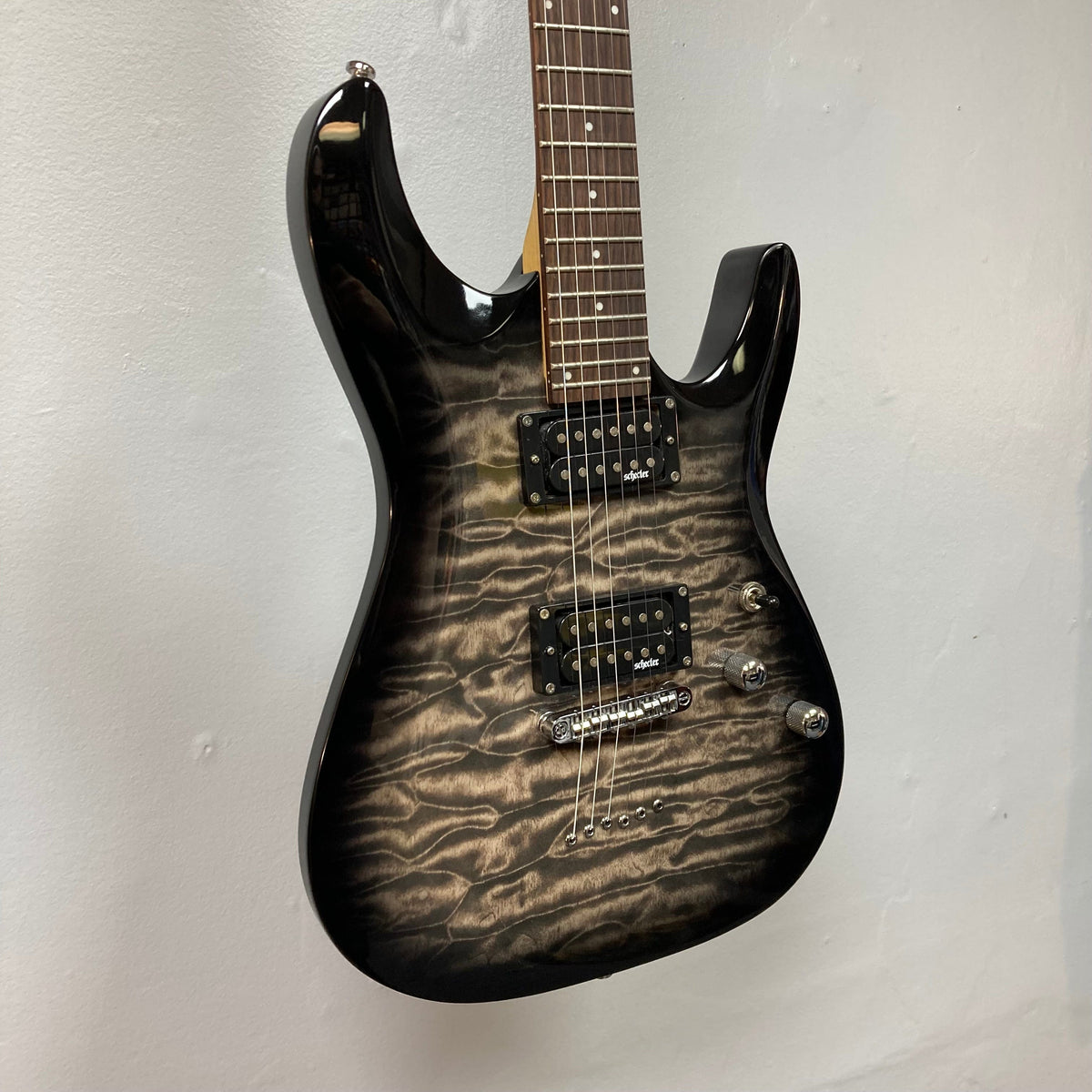 Schecter C6 Plus Charcoal Burst Used electric guitar showcasing close-up of its strings, bridge, and neck for enhanced playability and tuning stability.