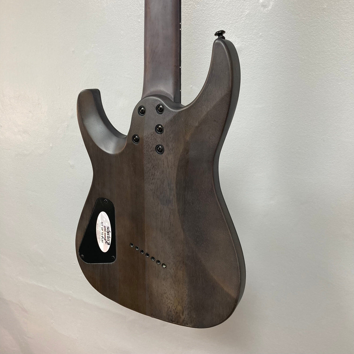 Close-up of the Schecter Omen Elite-7 Multiscale Black Cherry Burst guitar with visible finish blemishes and rosewood fretboard.