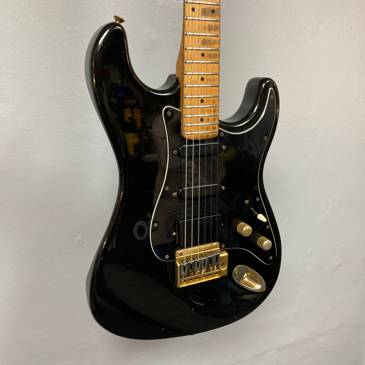 Schecter USA Super Strat 1983-1987 Black Gold electric guitar with gold hardware, featuring sleek design and detailed close-ups of knobs and neck.