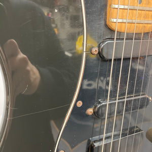 Schecter USA Super Strat electric guitar, close-up of strings and body, highlighting its craftsmanship.