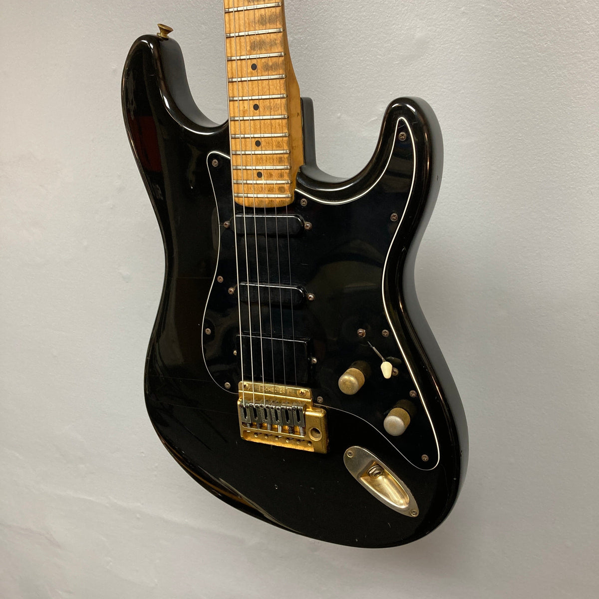 Schecter USA Super Strat 1983-1987 Black Gold electric guitar with gold hardware, showcasing its sleek design and detailed components.