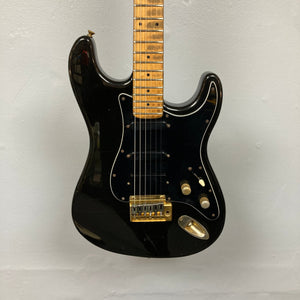 Schecter USA Super Strat 1983-1987 Black Gold electric guitar featuring gold hardware, highlighting its premium design and craftsmanship.