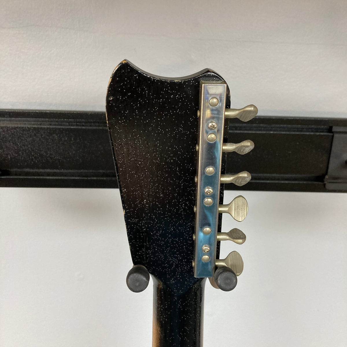 Close-up of the Sears Silvertone 1448 1960s Black Sparkle guitar, showcasing its neck and distinctive Amp-in-Case feature.