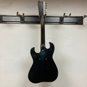 Sears Silvertone 1448 1960s Black Sparkle guitar with bolt-on neck and built-in case amplifier, displayed on a wall.