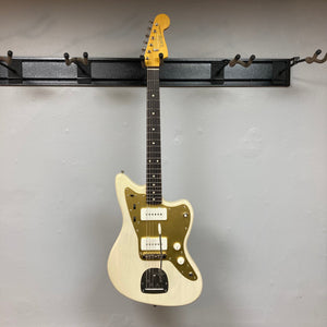 TopHat 59 Jazzavarius Blonde See Through Relic electric guitar with gold anodized guard, displayed on a wall.