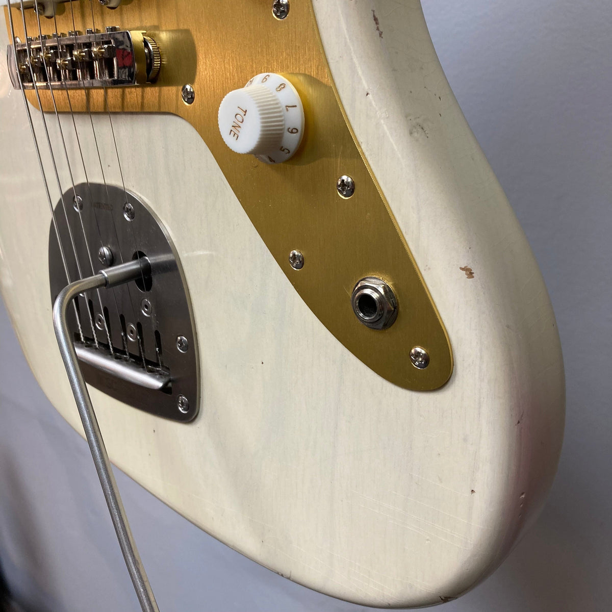 TopHat 59 Jazzavarius Blonde See Through Relic, close-up of guitar body, white knob, and strings, highlighting vintage and upgraded features.