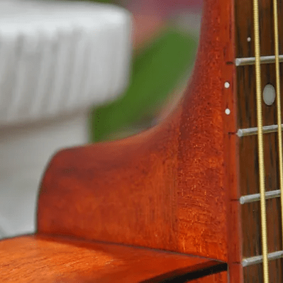 Close-up of the Bodhi BG10M African Okoume Mahogany Top Concert Body Acoustic Guitar, highlighting its detailed craftsmanship and string arrangement.