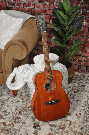 Bodhi BG10M African Okoume Mahogany Top Concert Body Acoustic Guitar leaning against a white statue.