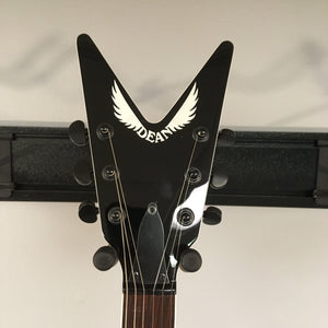 Dean Cadillac X Quilt Maple Trans Purple Burst guitar headstock close-up, showcasing white logo text and detailed string arrangement.