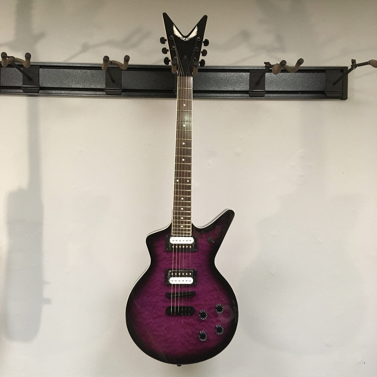 Dean Cadillac X Quilt Maple Trans Purple Burst electric guitar on display.