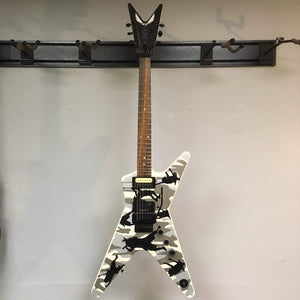 Dean Dime O Flage ML Electric Guitar with camouflage pattern displayed on a wall.