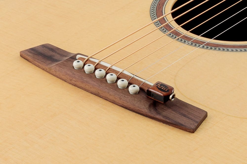 KNA SG-1 Portable Piezo Pickup for Steel String Guitar, close-up of guitar strings showing bridge-mounted piezo pickup installed securely between saddle and pins.