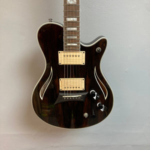 Michael Kelly Hybrid Special Ziricote, a versatile electric acoustic guitar with a ziricote top and chambered mahogany body, displayed on a wall.