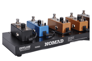 Multicolored guitar pedals arranged on the NOMAD-ISO-S rechargeable pedal board with integrated battery and multiple outputs.