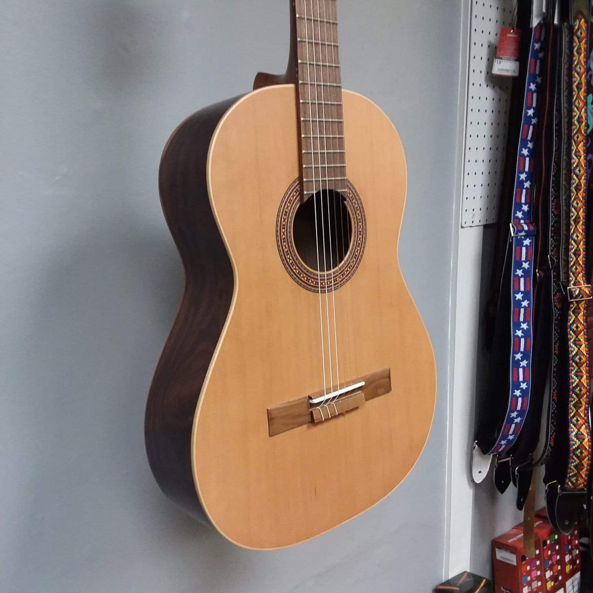 Ortega Nylon String Guitar R189SN-25TH on display, featuring solid American cedar top, Granadillo back and sides, and walnut fretboard. 25th Anniversary Series.