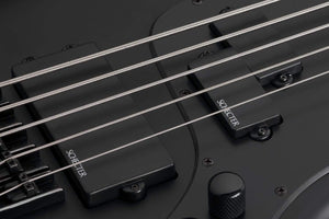 Schecter Stiletto Stealth-5 Satin Black electric guitar, close-up view highlighting the body, strings, metal knobs, and bridge.