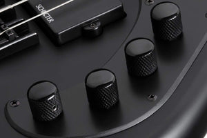 Close-up of the Schecter Stiletto Stealth-5 Satin Black guitar's black tuning knobs and hardware.